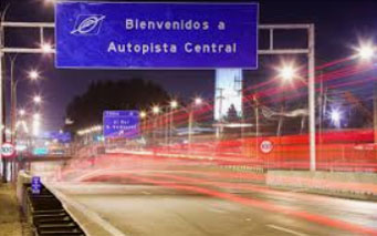 Ein blaues Verkehrsschild auf einer Straße bei Nacht.