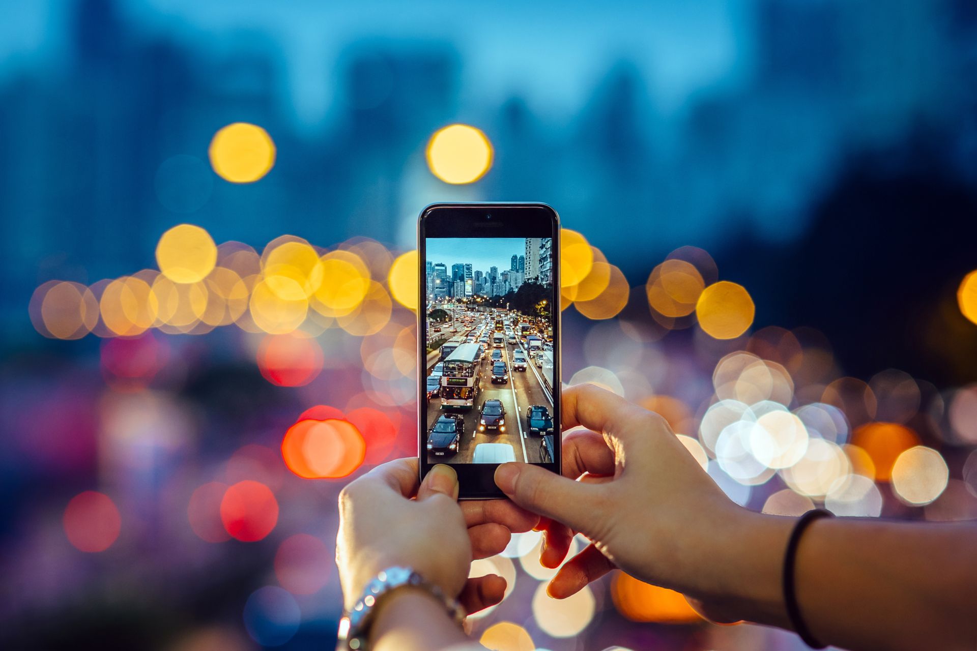 Eine Person fotografiert eine Straße mit einem Mobiltelefon.