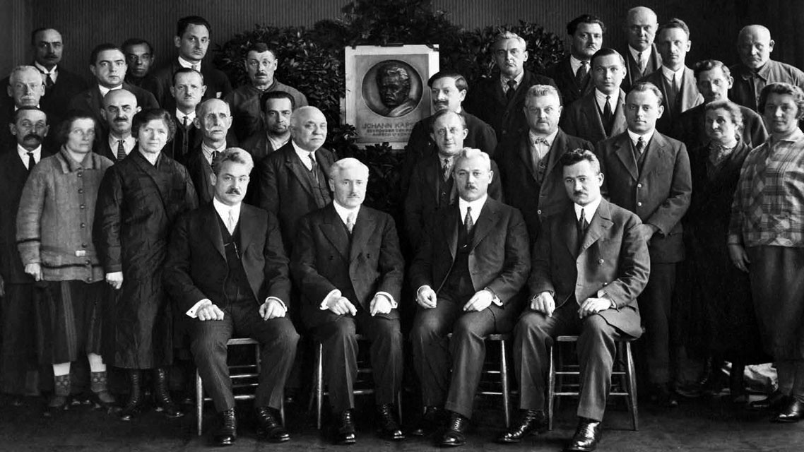 Eine Gruppe von Männern in Anzügen, darunter die vier Söhne von Johann Kapsch, die für verschiedene Bereiche des Unternehmens verantwortlich sind.