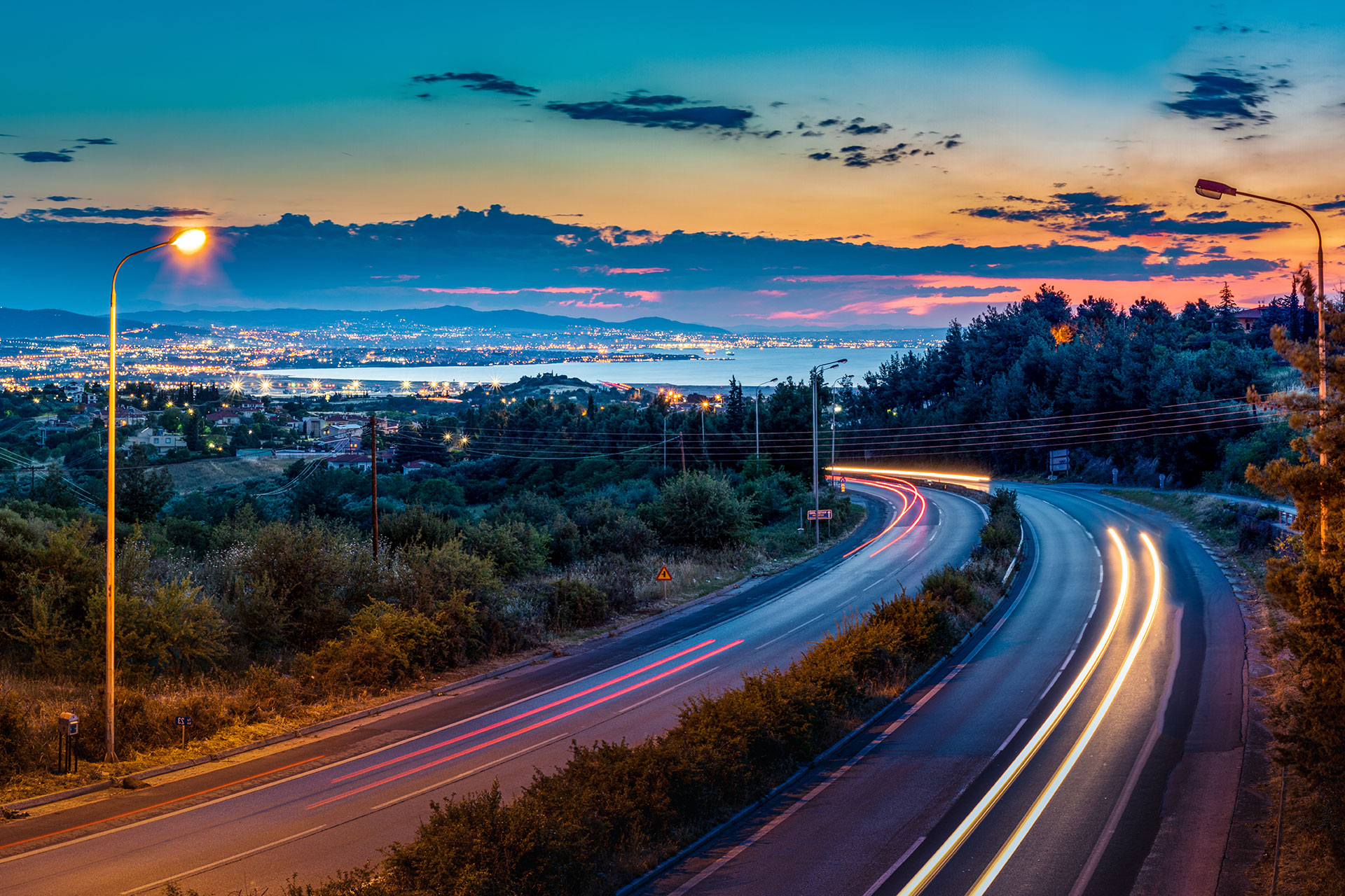 Carretera iluminada al anochecer en un entorno al aire libre, destacando la infraestructura vial.