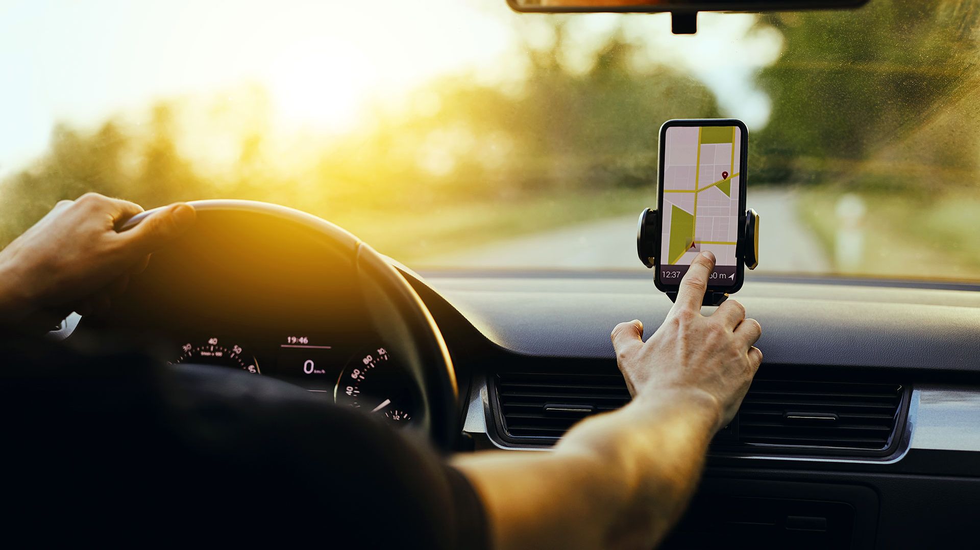 A person using a mobile phone navigation inside a car.
