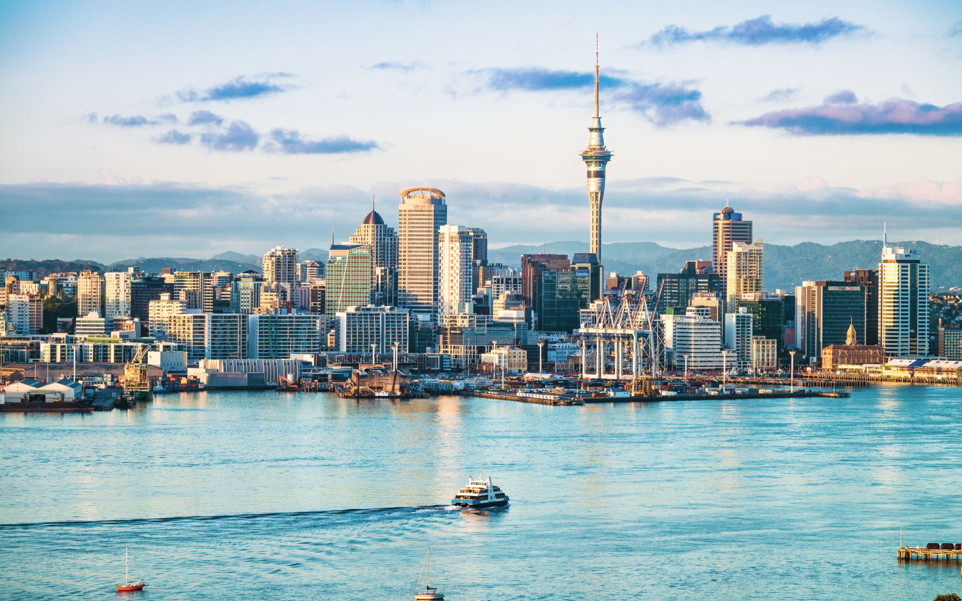 City skyline with a body of water and clouds in the sky.