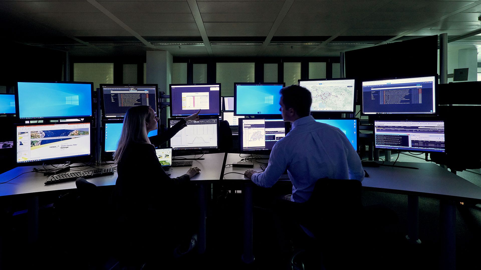 two people in front of screens at a traffic management center
