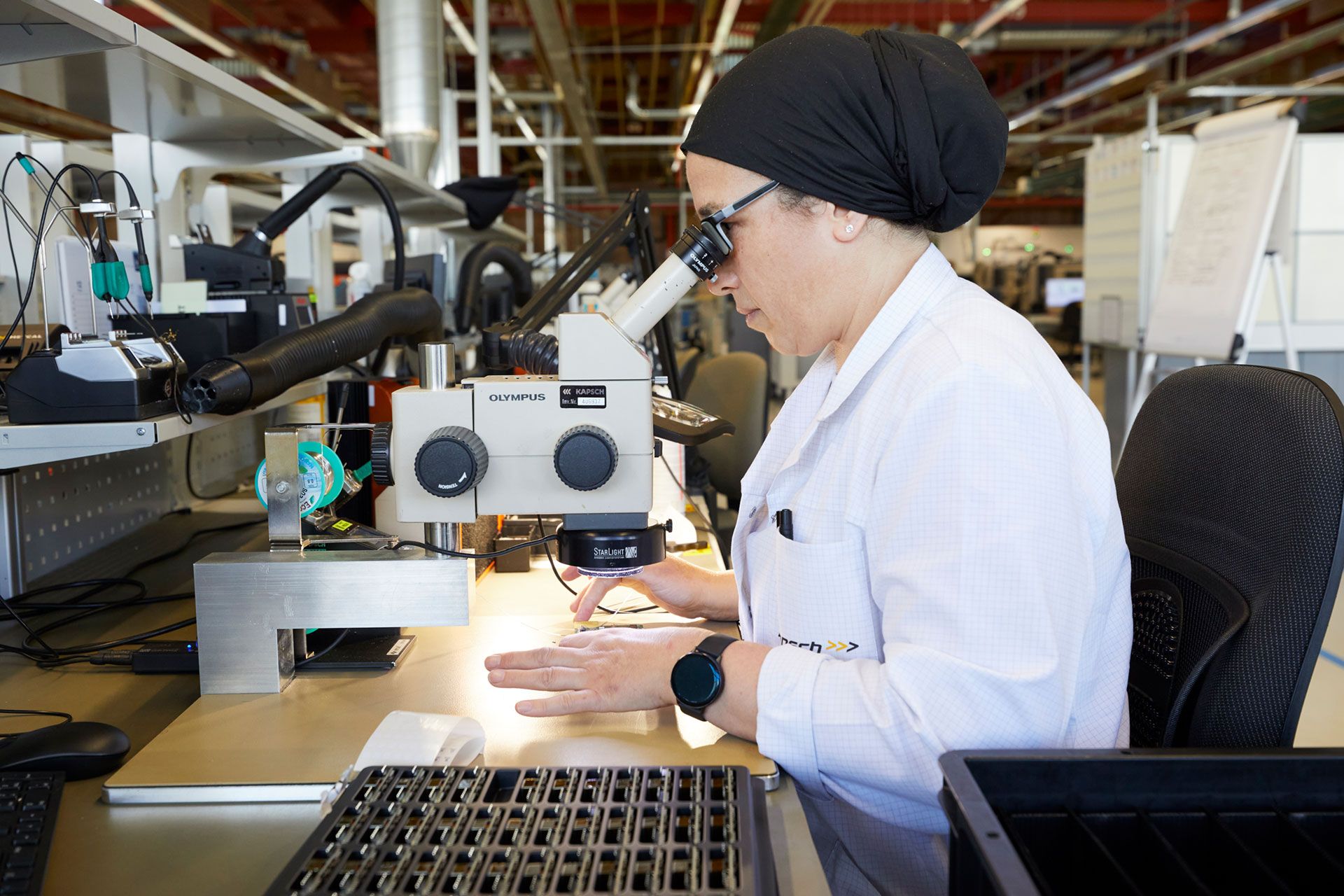 A woman technician looking through a microscope in a research institute.