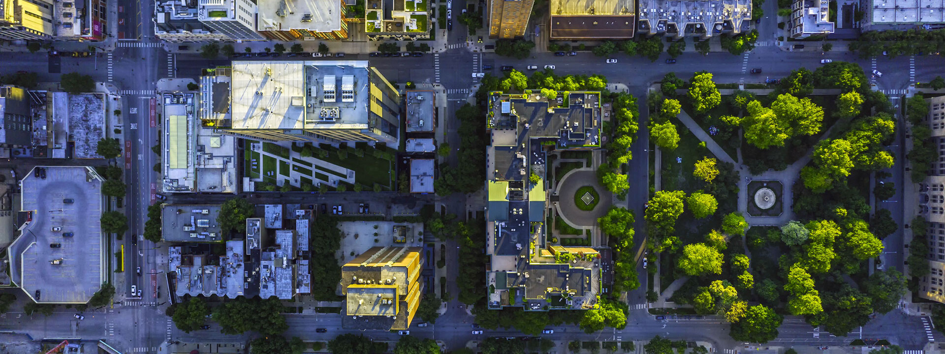 © Kapsch TrafficCom Luftaufnahme einer Stadt mit vielen Gebäuden und Bäumen, im Kontext von Kapsch TrafficComs Bemühungen zur Verbesserung der Luftqualität in urbanen Gebieten.