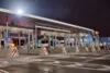 A gas station at night, highlighting the building and illuminated gas pumps.