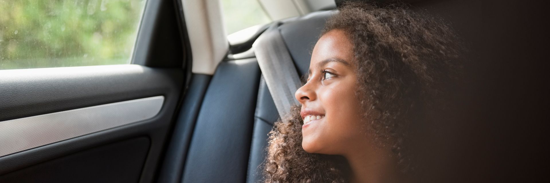 Una mujer sonriendo dentro de un coche en el contexto de la visión y misión de Kapsch sobre movilidad sostenible.